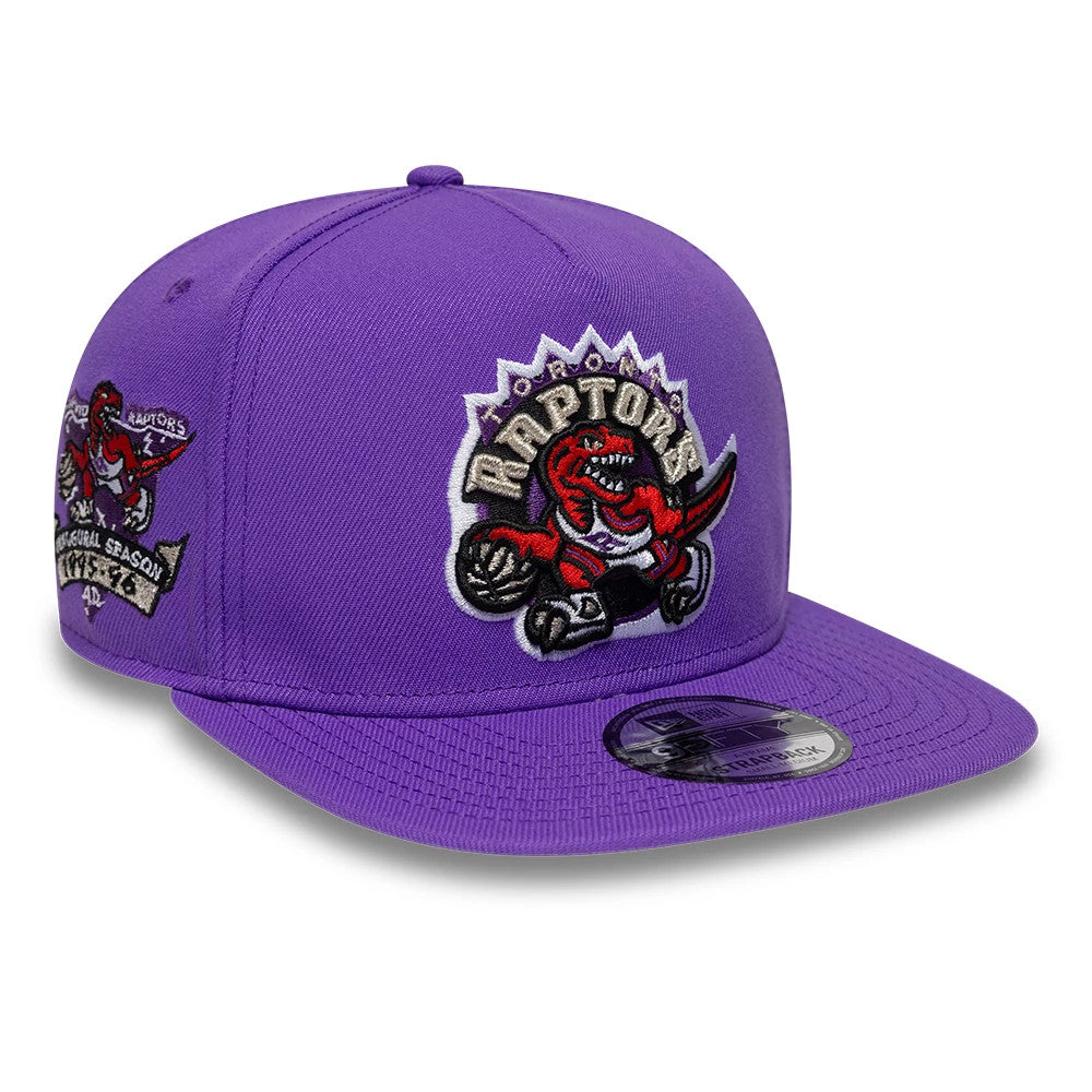 Toronto Raptors NBA Hardwood Classic Bright Purple New Era 9FIFTY A-Frame Snapback Adjustable Cap, three-quarter view showing a large, red and black embroidered Raptors logo on the front panel, a flat purple visor with a 9FIFTY size sticker.