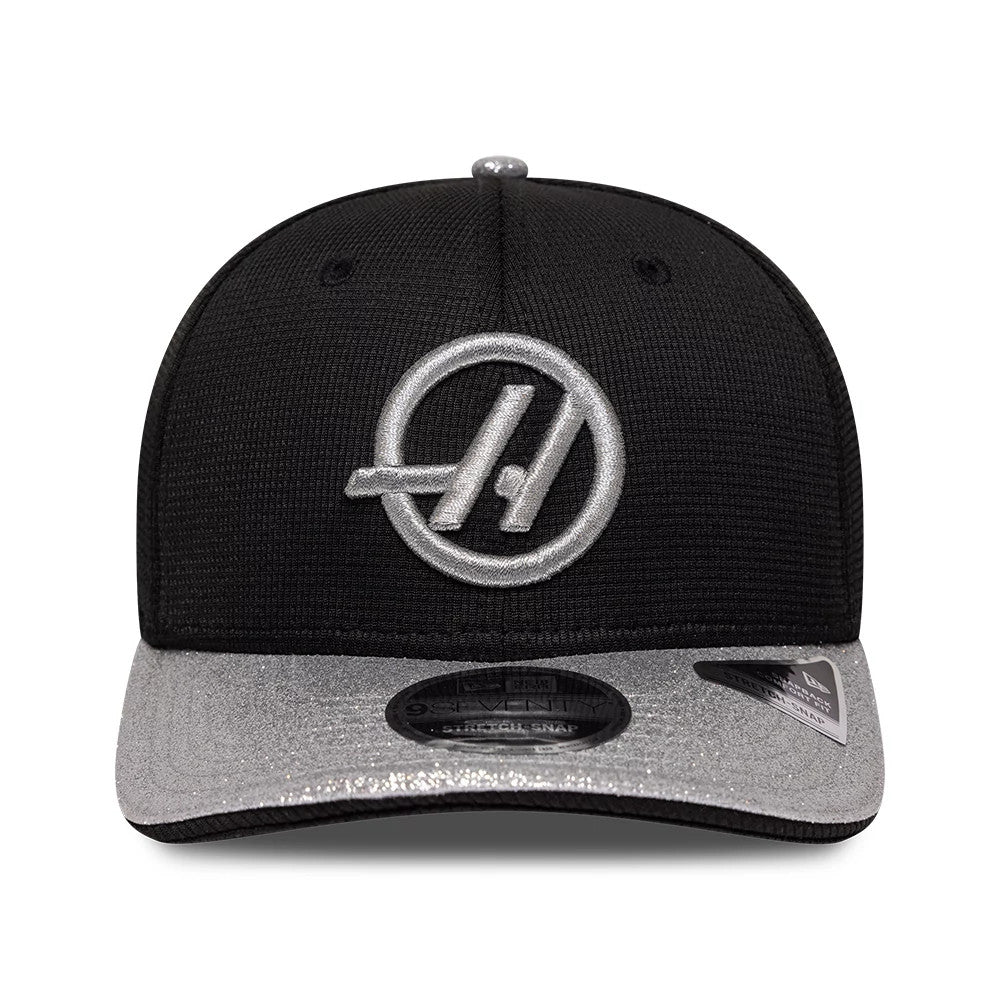 TGR Haas F1 Vegas Race Special Black New Era 9SEVENTY Stretch Snap Adjustable Cap, front view showing the raised silver embroidered Haas logo on the structured black crown, with a silver visor and a 9SEVENTY size sticker.