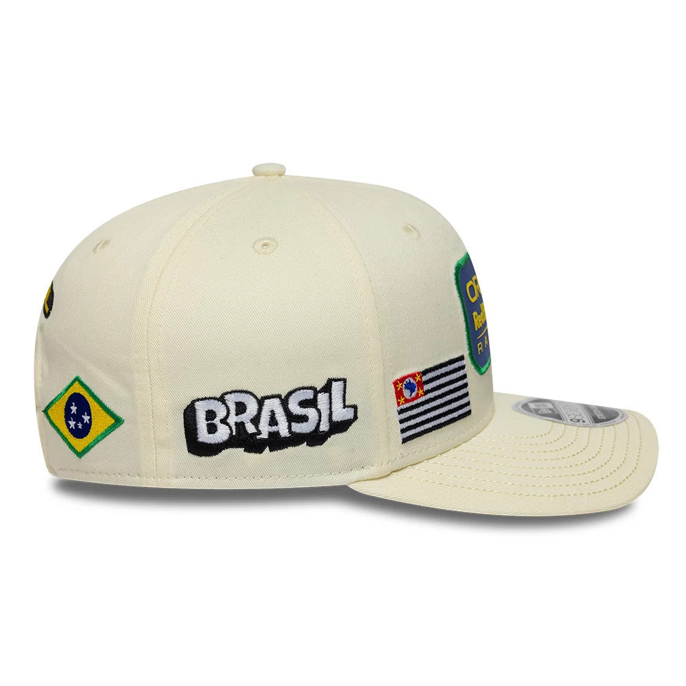 Red Bull Racing Brazil Race Special Team Cream New Era 9SEVENTY Stretch Snap Adjustable Cap, side view showing the embroidered BRASIL text, a Brazilian flag badge on the side panel, and a white 9SEVENTY size sticker on the cream visor.