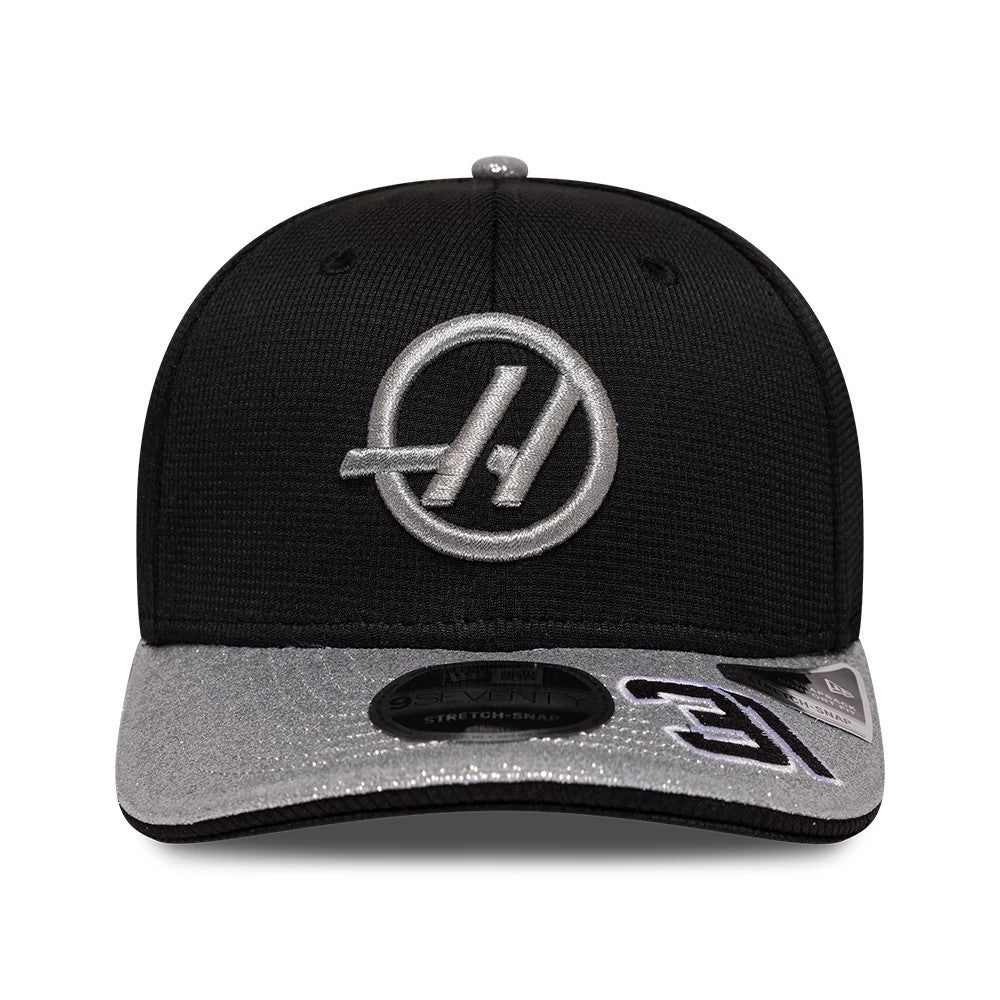 TGR Haas F1 Esteban Ocon Vegas Race Special Black New Era 9SEVENTY Stretch Snap Adjustable Cap, front view showing a silver embroidered Haas logo on the structured black crown, with a grey visor featuring a 9SEVENTY size sticker and a black edge.