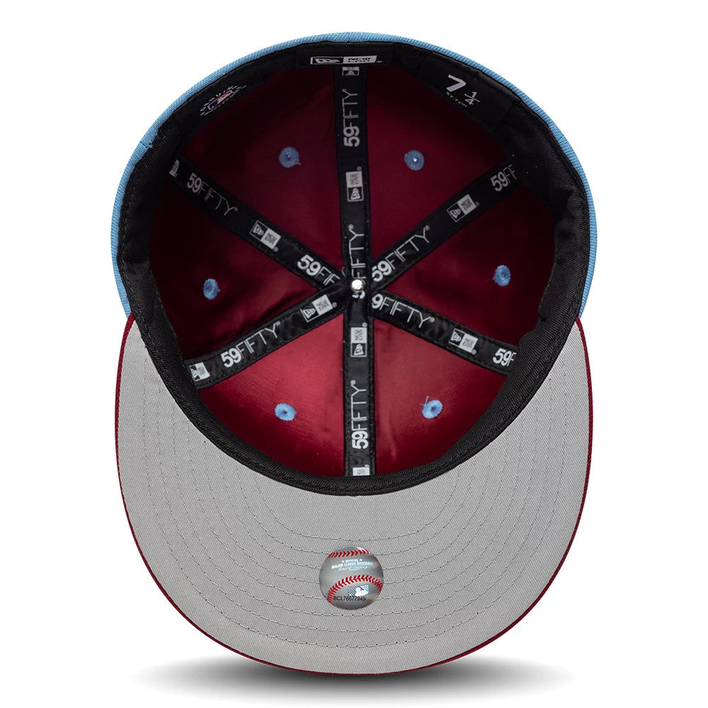Philadelphia Phillies MLB Multi Logo Satin Lined Pastel Blue New Era 59FIFTY Fitted Cap, inside view showing red satin lining, black taping with repeated white 59FIFTY logos, and a grey undervisor with a baseball graphic underneath.