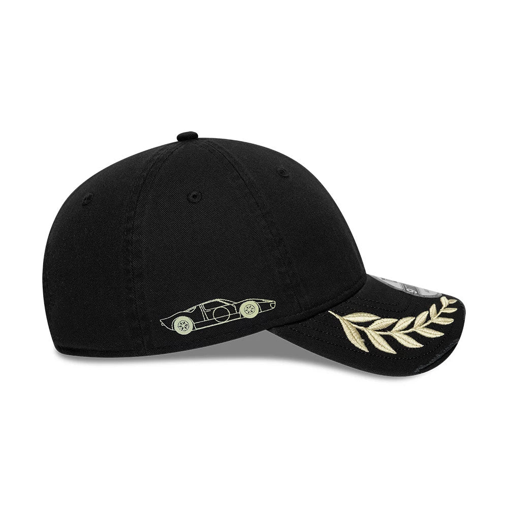 24HR Le Mans Washed Graphic Black New Era 9TWENTY Adjustable Cap, side view showing an embroidered racing car graphic on the black structured crown, a gold laurel motif on the curved visor, and an adjustable strap at the back.