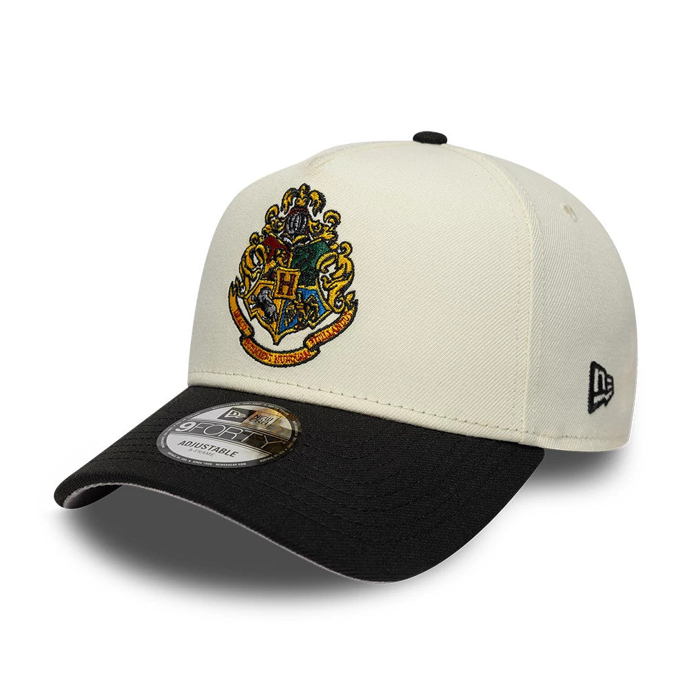 Harry Potter Hogwarts White & Black New Era 9FORTY A-Frame Adjustable Cap, three-quarter view showing the Hogwarts crest embroidered in vivid colours on the front panel, a black curved visor with a 9FORTY size sticker.
