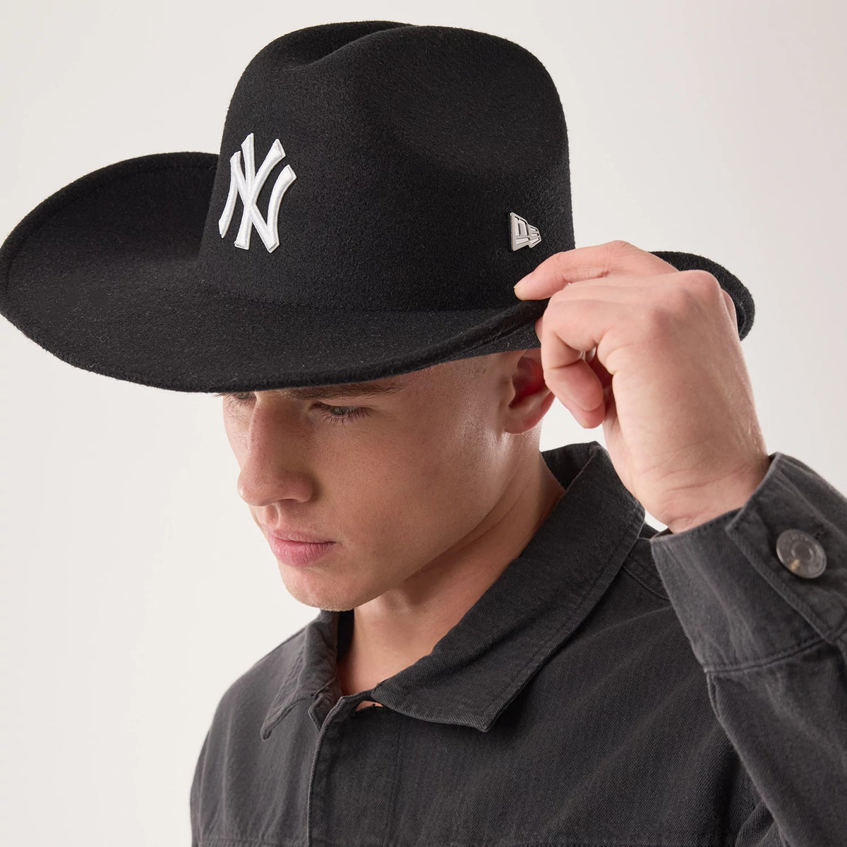 New Era New York Yankees MLB Black Wide Brim Fedora Cowboy Hat, on-model view featuring a large white embroidered NY logo on the front, a structured wide visor in felt material, and the New Era flag logo on the right side.