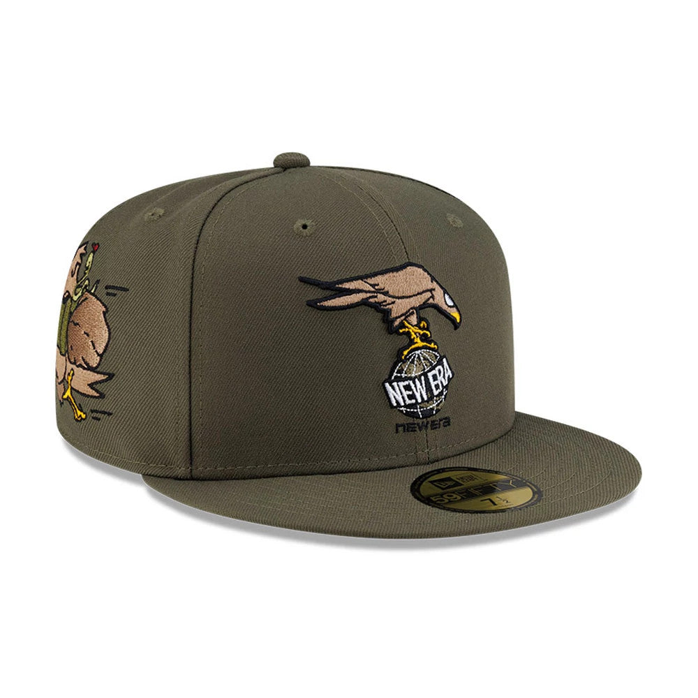 Roji Soccer Green New Era 59FIFTY Fitted Cap, three-quarter view showing a brown and yellow eagle with a globe embroidered on the front panel, additional cartoon eagle graphic on the side, and a gold 59FIFTY size sticker on the flat visor.