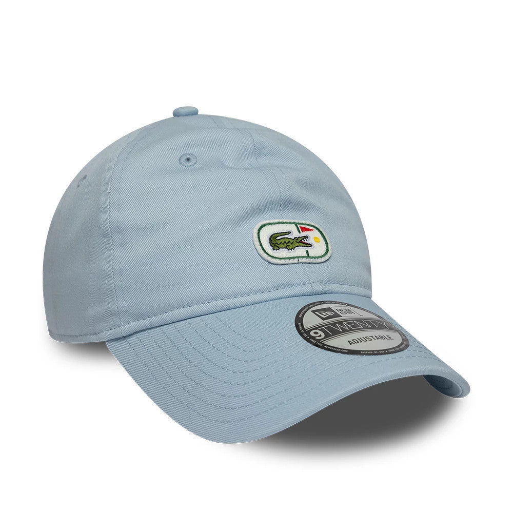 Lacoste X New Era Pastel Blue 9TWENTY Adjustable Cap, front view showing the embroidered Lacoste crocodile logo on the front panel, complemented by a curved pastel blue visor and a 9TWENTY size sticker centrally placed on the visor.