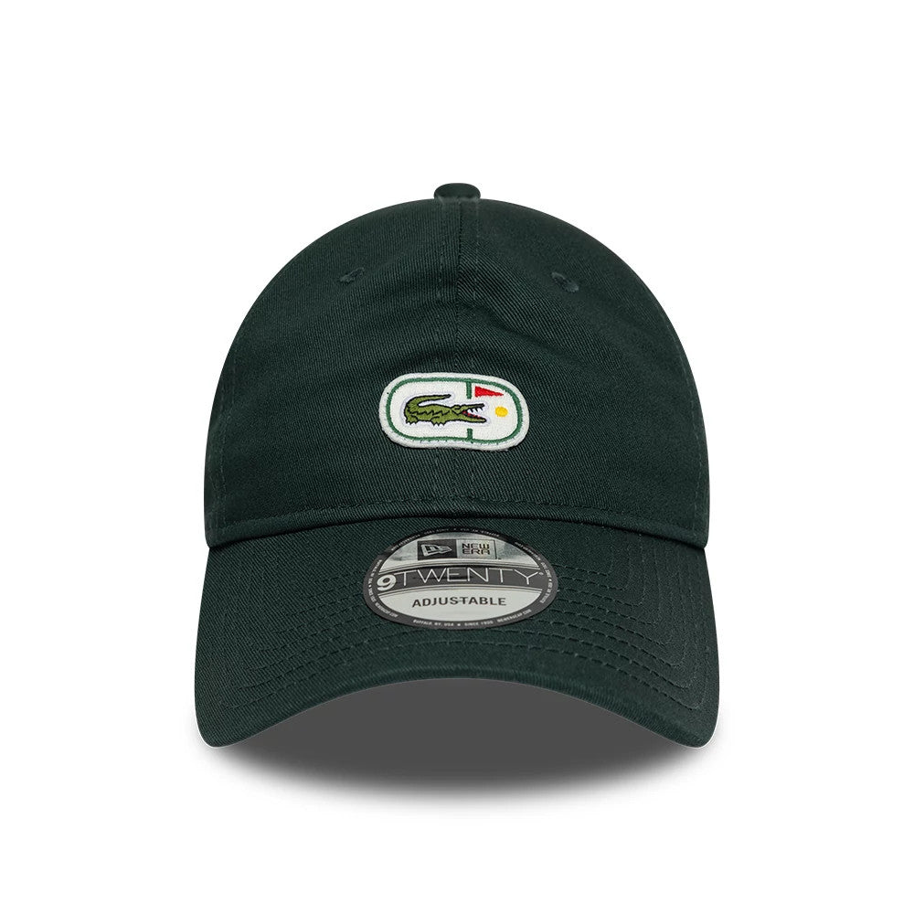 Lacoste X New Era Dark Green 9TWENTY Adjustable Cap, front view showing the embroidered Lacoste crocodile logo on the front panel, a curved visor, and the 9TWENTY size sticker centred on the dark green fabric.
