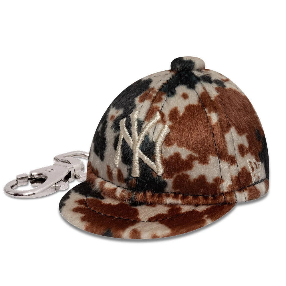 New Era New York Yankees MLB Animal Mini Cap Brown Key Chain, three-quarter view showing a brown animal-patterned design with a cream embroidered NY logo on the front panel, curved plush visor, and silver clip attachment on the left side.