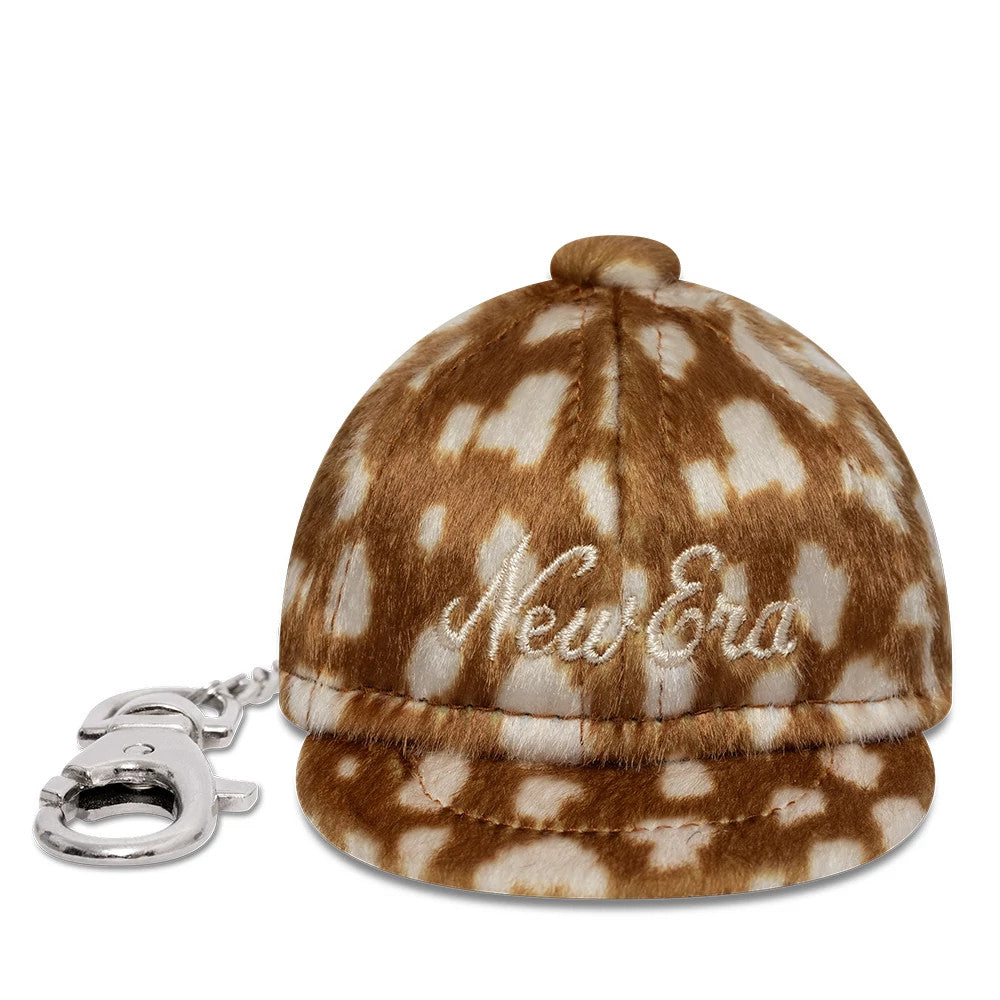 New Era MLB Animal Mini Cap Cow Print Key Chain, front view showing white embroidered New Era lettering on the brown and white cow print cap, complete with a small visor and a key chain attached to the back.
