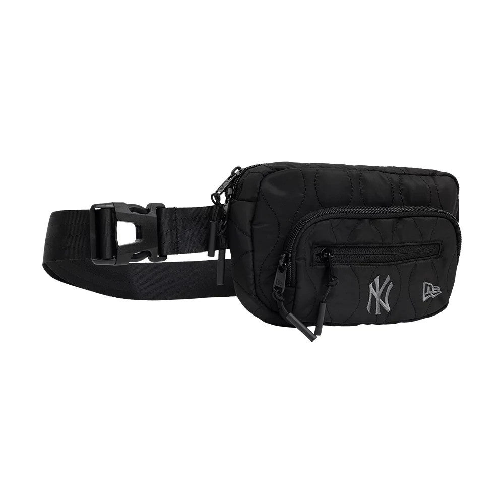 New Era New York Yankees MLB Black Padded Utility Waist Bag, side view featuring a compact black design, two zipped compartments on the front, an embroidered New York Yankees logo to the left, and a debossed New Era logo to the right.