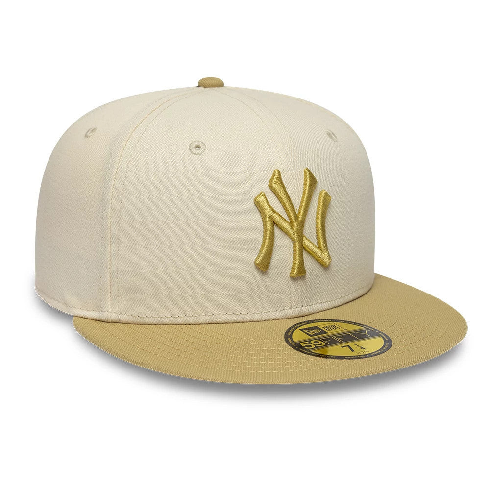 New York Yankees MLB League Essential Cream & Gold New Era 59FIFTY Fitted Cap, three-quarter view showing the gold embroidered NY logo on the structured cream crown, with a textured gold visor and a matching gold 59FIFTY size sticker.