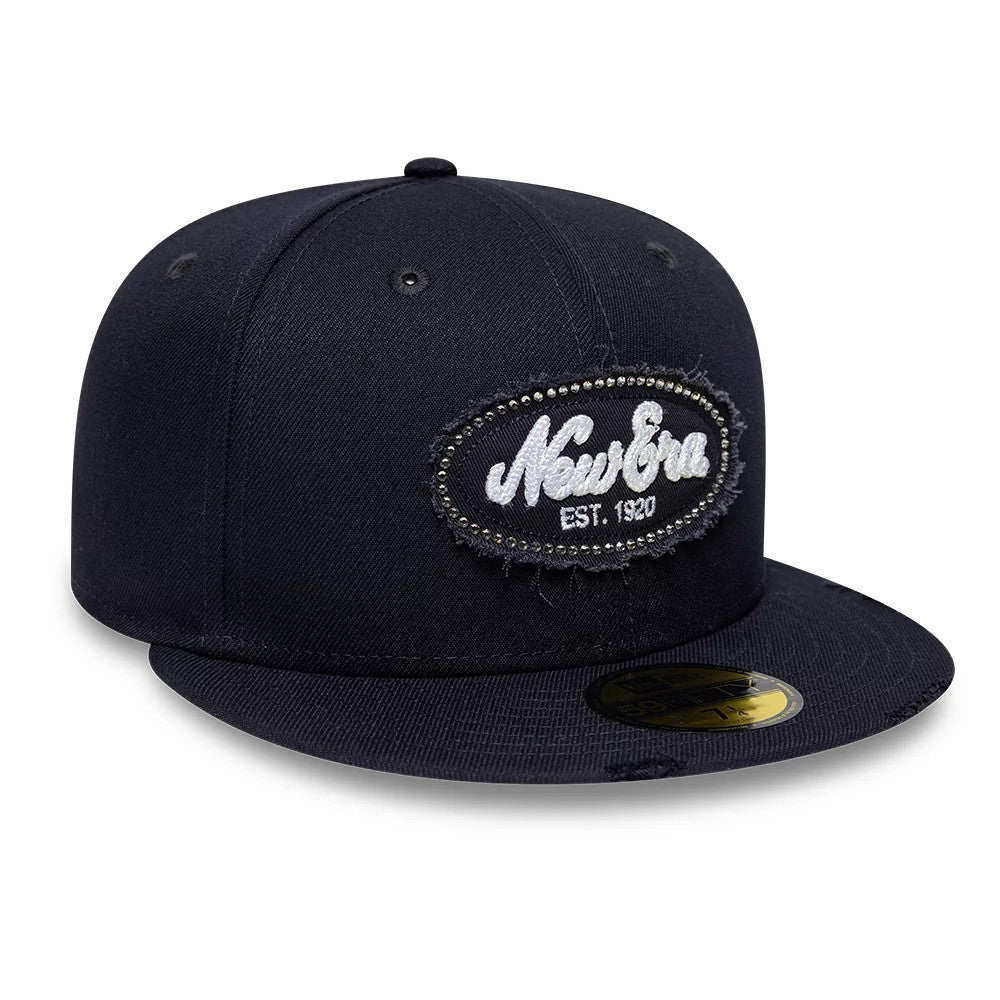New Era Gem Patch Distress Navy 59FIFTY Fitted Cap, front view showing a distressed oval patch with white embroidered New Era lettering and small gems outlining the patch, a structured navy crown, and the gold 59FIFTY size sticker on the flat visor.