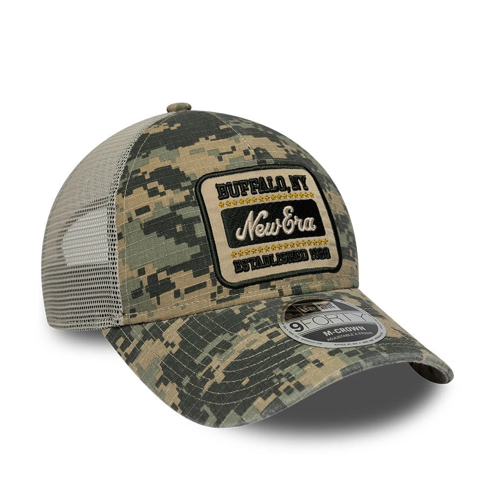 New Era Camo Dark Green 9FORTY M-Crown A-Frame Trucker Adjustable Cap, front view showing a black and gold embroidered patch on the structured camo front panel, black mesh side panels, and a 9FORTY size sticker on the curved visor.
