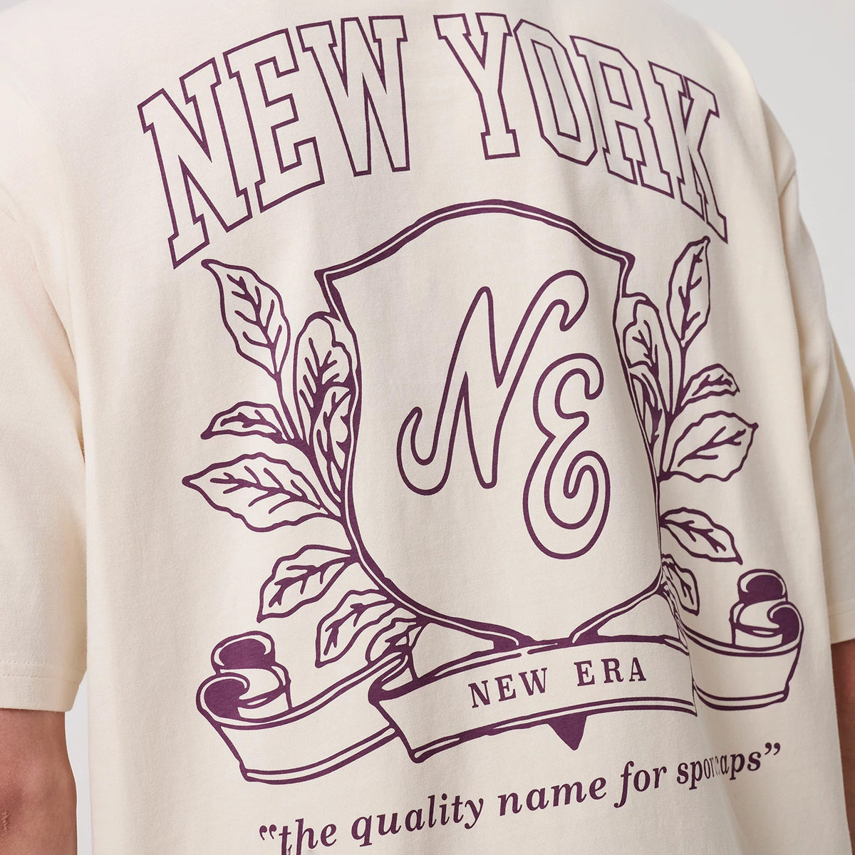 The model is wearing this New Era Crest Graphic Oversized T-Shirt in open white. 8