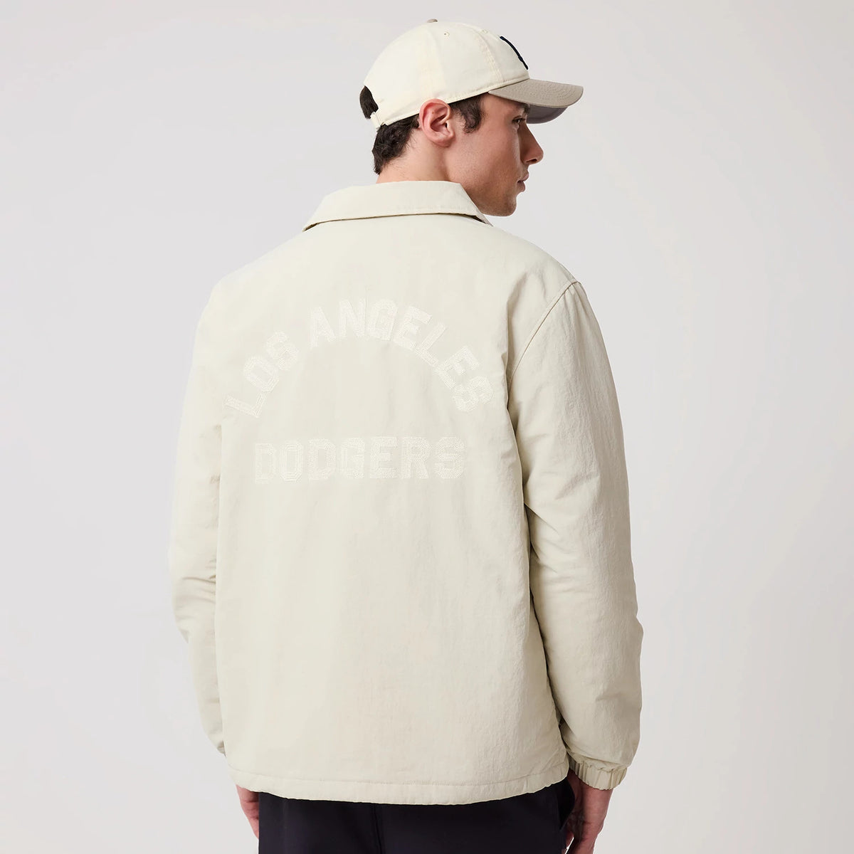 The model is wearing this MLB LA Dodgers Coach Jacket in light beige. 2