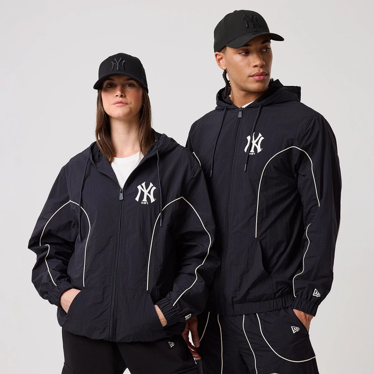 New Era New York Yankees MLB Piping Navy Track Jacket, on-model view featuring the navy jacket with white piping accents along the sleeves and body, an embroidered New York Yankees logo on the left chest.