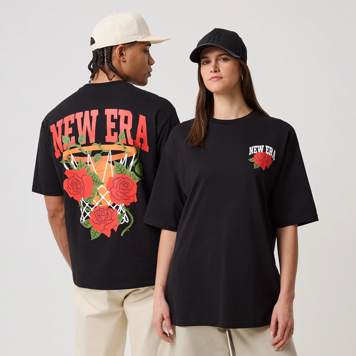 New Era Floral Graphic Black T-Shirt, front and back view on models; front features a smaller New Era logo with a rose graphic on the chest, back displays a basketball hoop with roses and large New Era lettering in red across the shoulders.