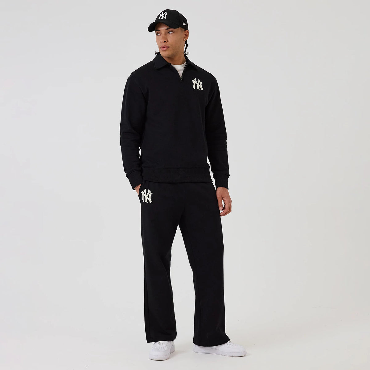 The model is wearing this MLB New York Yankees 1/4 Zip Sweater in black. 8