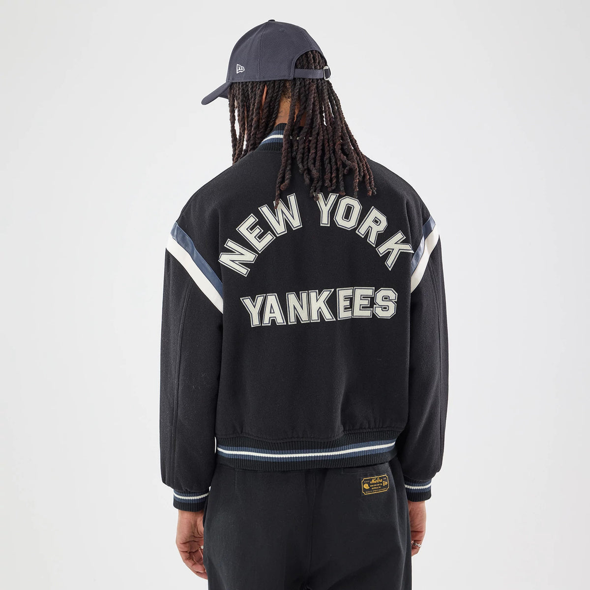 The model is wearing this MLB New York Yankees Varsity Jacket in black. 7