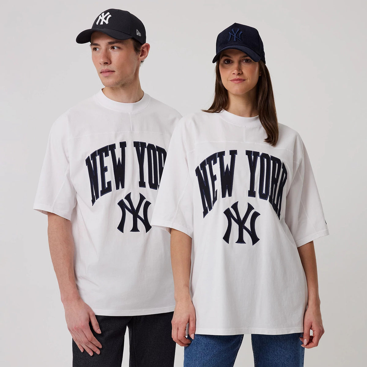 New Era New York Yankees MLB Arch Graphic White Oversized T-Shirt, front view on-model showcasing navy New York lettering arched across the chest with the Yankees logo beneath, worn over dark jeans.