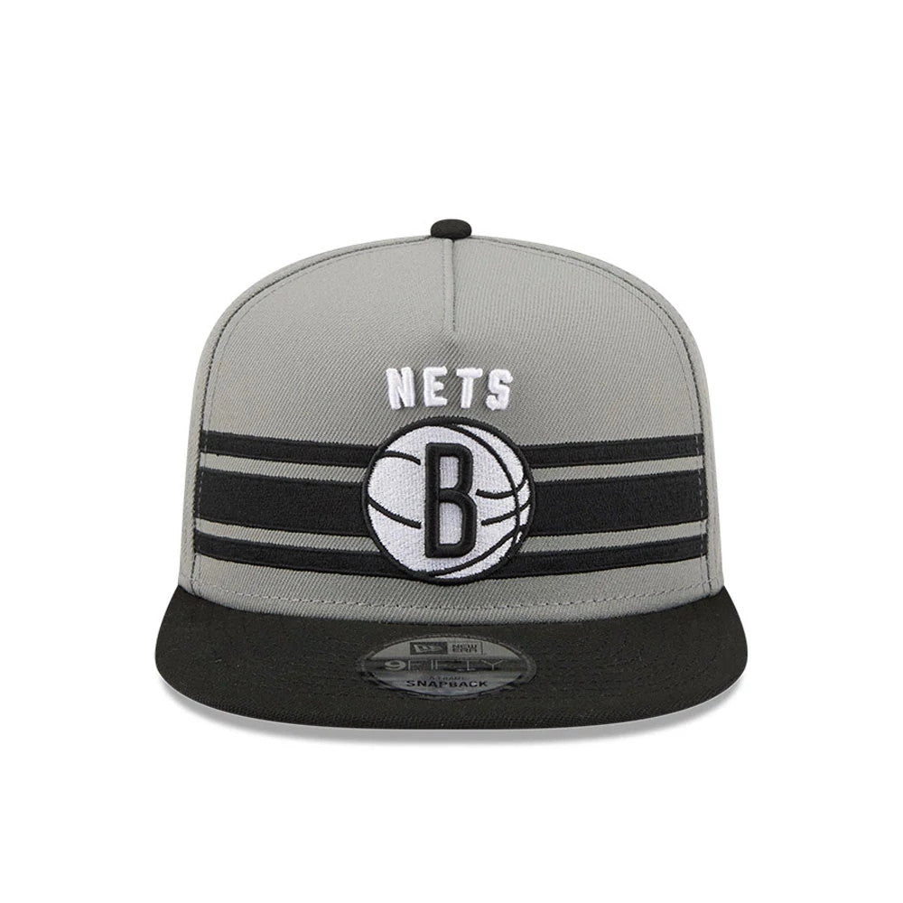 Brooklyn Nets NBA Tip Off 2026 Dark Grey New Era 9FIFTY A-Frame Snapback Adjustable Cap, front view showing the raised embroidered white NETS text and black B logo on the centre front panel, with a black flat visor featuring a 9FIFTY size sticker.