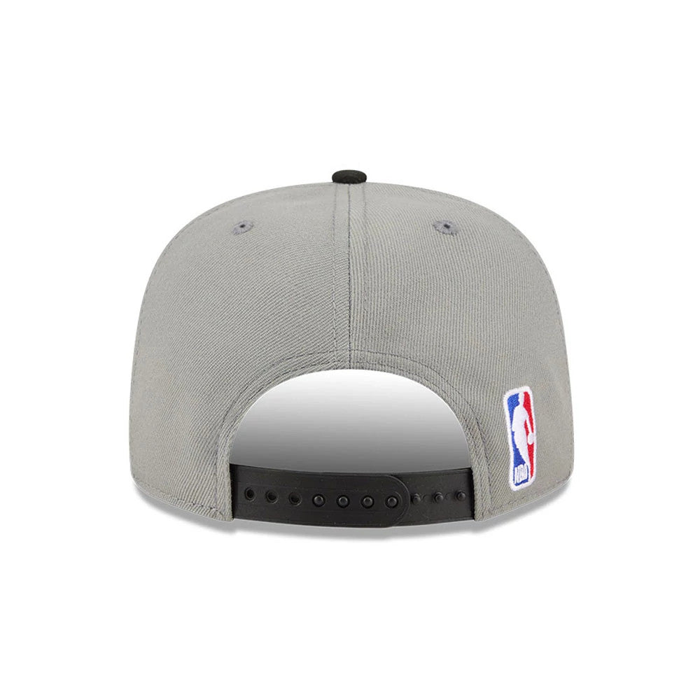 Brooklyn Nets NBA Tip Off 2026 Dark Grey New Era 9FIFTY A-Frame Snapback Adjustable Cap, rear view showing an embroidered NBA logo on the left side of the light grey structured crown, with a black adjustable snapback closure and two grey eyelets.