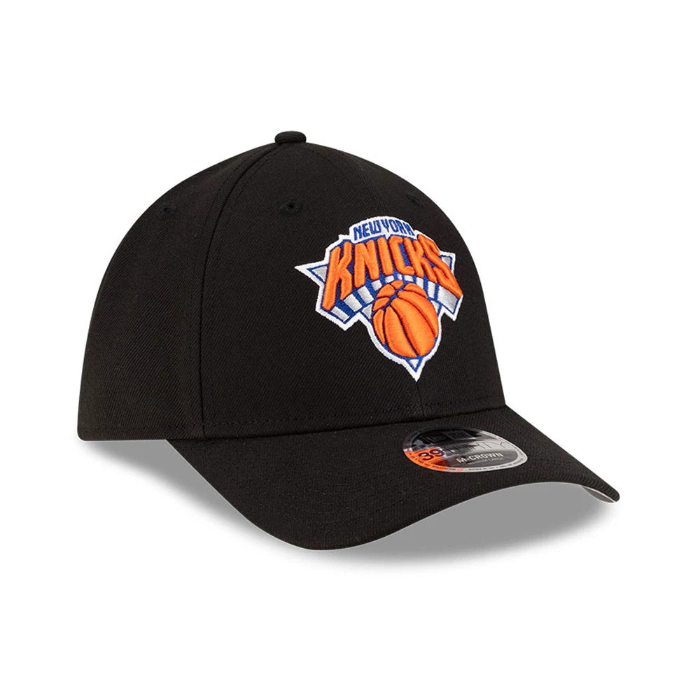 New York Knicks NBA Team Black New Era 39THIRTY M-Crown Stretch Fit Cap, three-quarter view showing the vivid orange and blue embroidered Knicks logo on the front panel, with a black curved visor and a 39THIRTY size sticker at the centre.