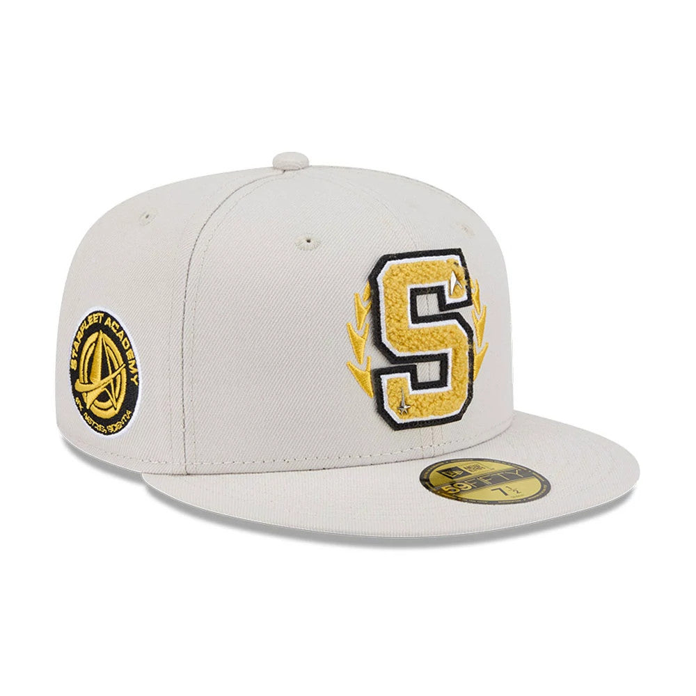 Star Trek Logo Light Beige New Era 59FIFTY Fitted Cap, three-quarter view showing a large yellow chenille ‘S’ with gold wreath embroidery on the front panel, Starfleet Academy patch on the left side, and gold 59FIFTY size sticker on the beige visor.