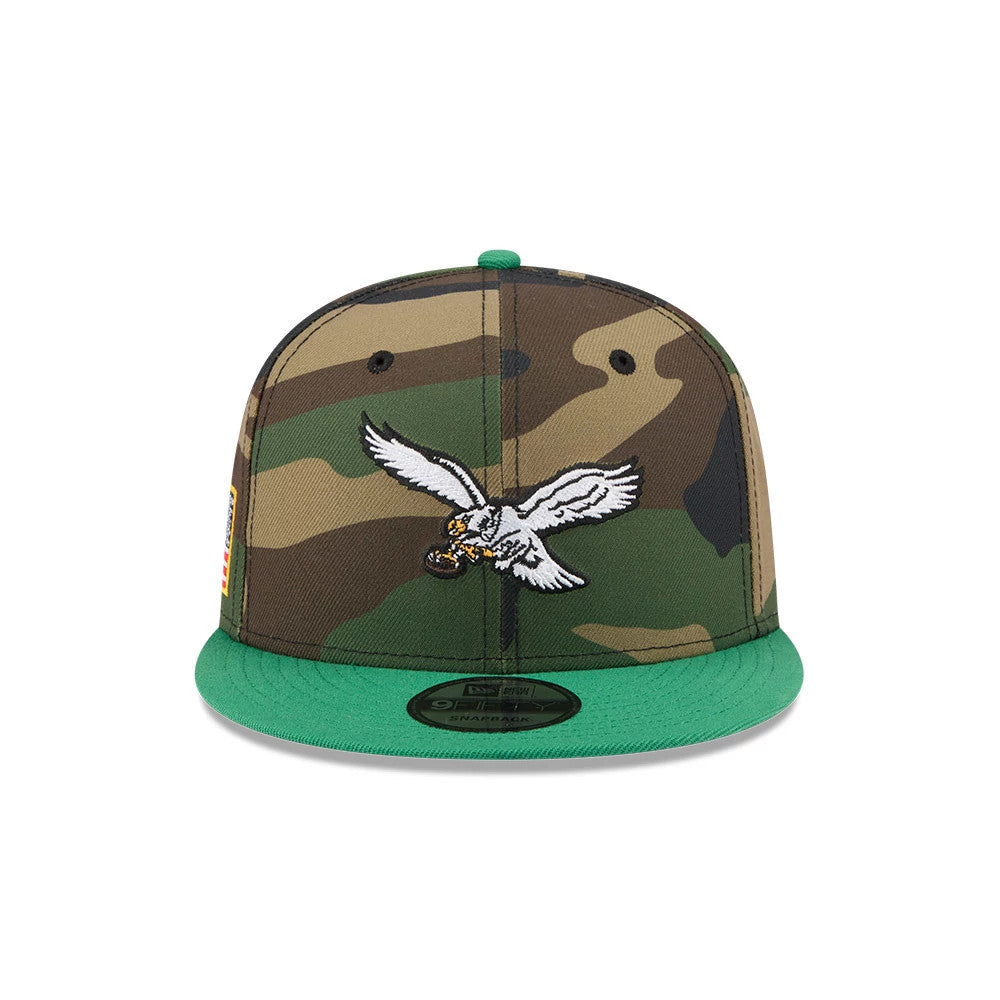 Philadelphia Eagles NFL Camo & Green New Era 9FIFTY Snapback Adjustable Cap, front view showing the raised embroidered white eagle mascot logo on the centre camo panel, with green visor and the 9FIFTY size sticker on the flat green visor.