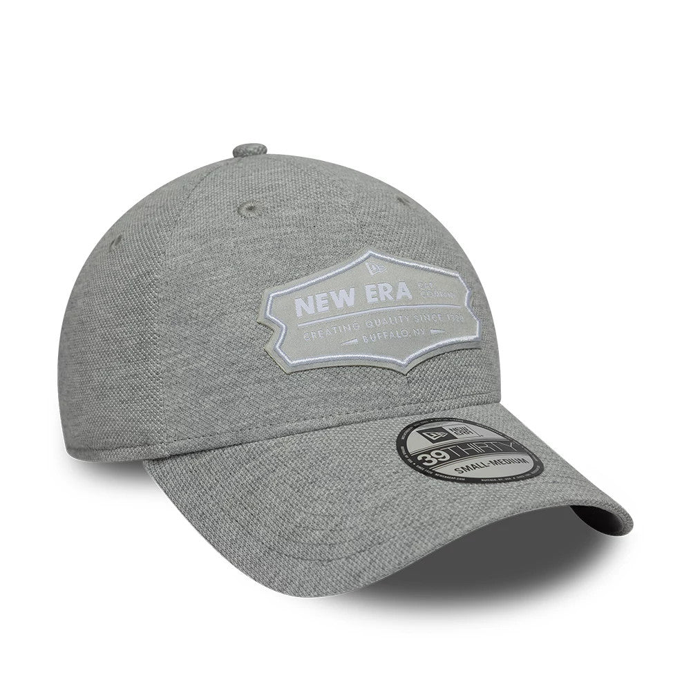 New Era Jersey Grey New Era 39THIRTY Stretch Fit Cap, three-quarter view showing a grey front panel with a white embroidered patch, curved grey visor with a 39THIRTY size sticker, and a well-fitted stretch design.