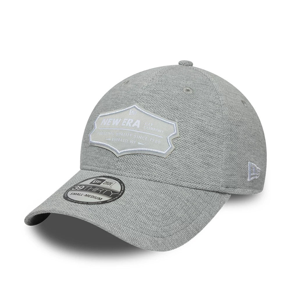 New Era Jersey Grey 39THIRTY Stretch Fit Cap, three-quarter view showing a grey fabric front with a large embroidered New Era badge in white, a bent visor with a 39THIRTY size sticker, and the New Era flag logo on the left side.
