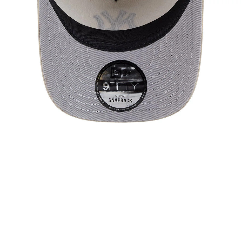New York Yankees MLB Light Beige New Era 9FIFTY A-Frame Snapback Adjustable Cap, inside view showing the grey undervisor with a 9FIFTY A-Frame Snapback size sticker, dark sweatband, and faintly New York Yankees logo shadow.