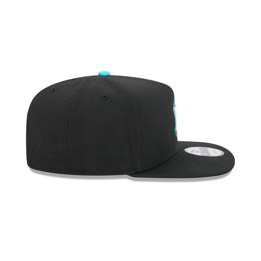 Yankees MLB Electrocute Black New Era 9FIFTY A-Frame Snapback Adjustable Cap, side view showing the flat black visor, an aqua top button matching the side logo embroidery peeking from the right front panel, and a 9FIFTY size sticker on the visor.