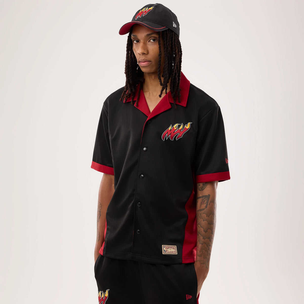 The model is wearing this NBA Hardwood Classic Revere Miami Heat Short Sleeve Shirt in black. 1