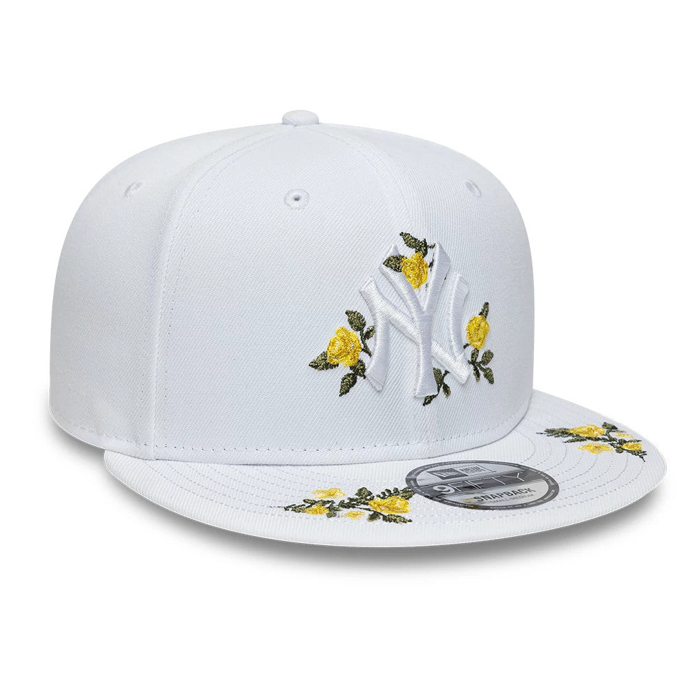 New York Yankees MLB Floral White New Era 9FIFTY Snapback Adjustable Cap, three-quarter view showing the raised white NY logo with yellow floral embroidery on the front panels and visor, with a 9FIFTY size sticker on the flat white visor.