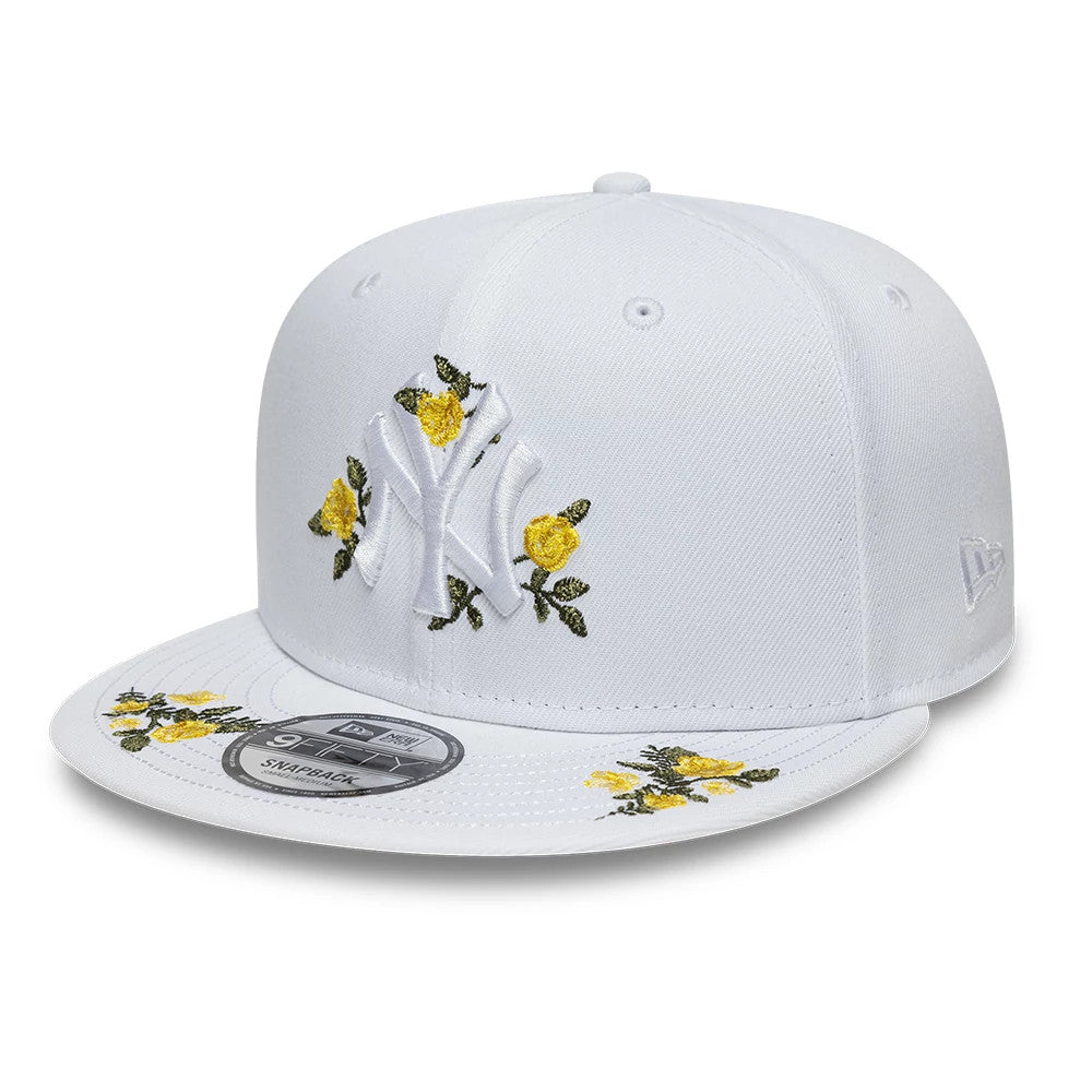 New York Yankees MLB Floral White New Era 9FIFTY Snapback Adjustable Cap, front view showing the raised embroidered white NY logo adorned with yellow floral accents, floral embroidery on the visor, and the 9FIFTY size sticker on the flat visor.