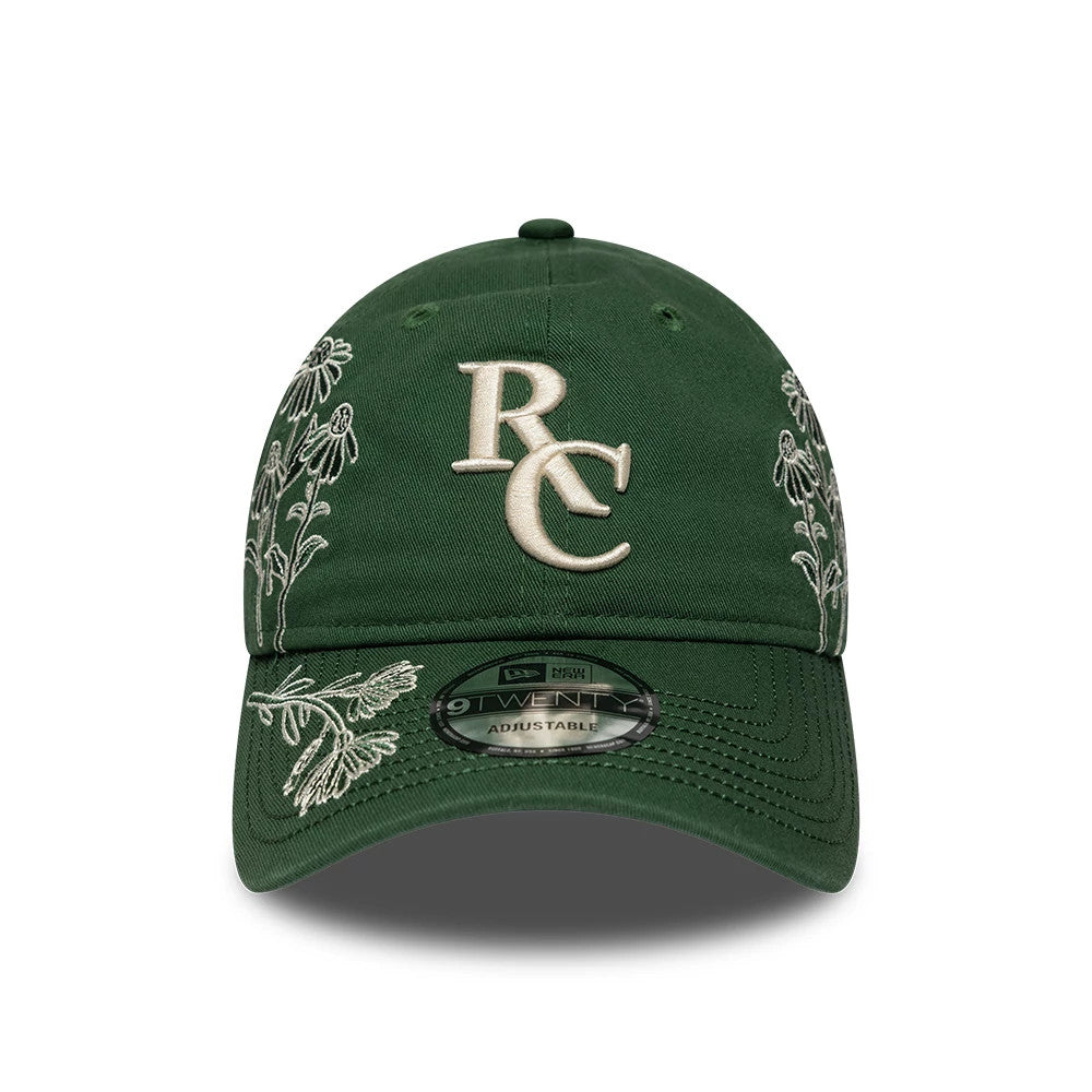 Ryder Cup 2027 All Over Print Dark Green New Era 9TWENTY Adjustable Cap, front view showing the raised beige RC logo embroidered on the front panel, with floral embroidery on the dark green crown and the 9TWENTY size sticker on the curved visor.