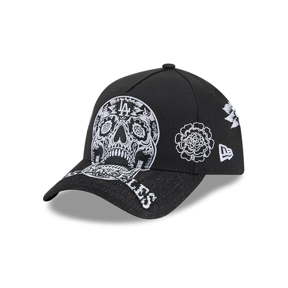 LA Dodgers MLB Day Of The Dead Black New Era 9FORTY A-Frame Adjustable Cap, three-quarter view showing the intricately embroidered white skull motif on the front panels, white floral designs on the left side, and Los Angeles text on the black visor.