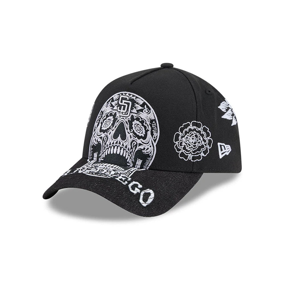 San Diego Padres MLB Day Of The Dead Black New Era 9FORTY A-Frame Adjustable Cap, three-quarter view showing a white embroidered sugar skull design on the front panels, San Diego lettering on the curved black visor, and floral motifs on the sides.