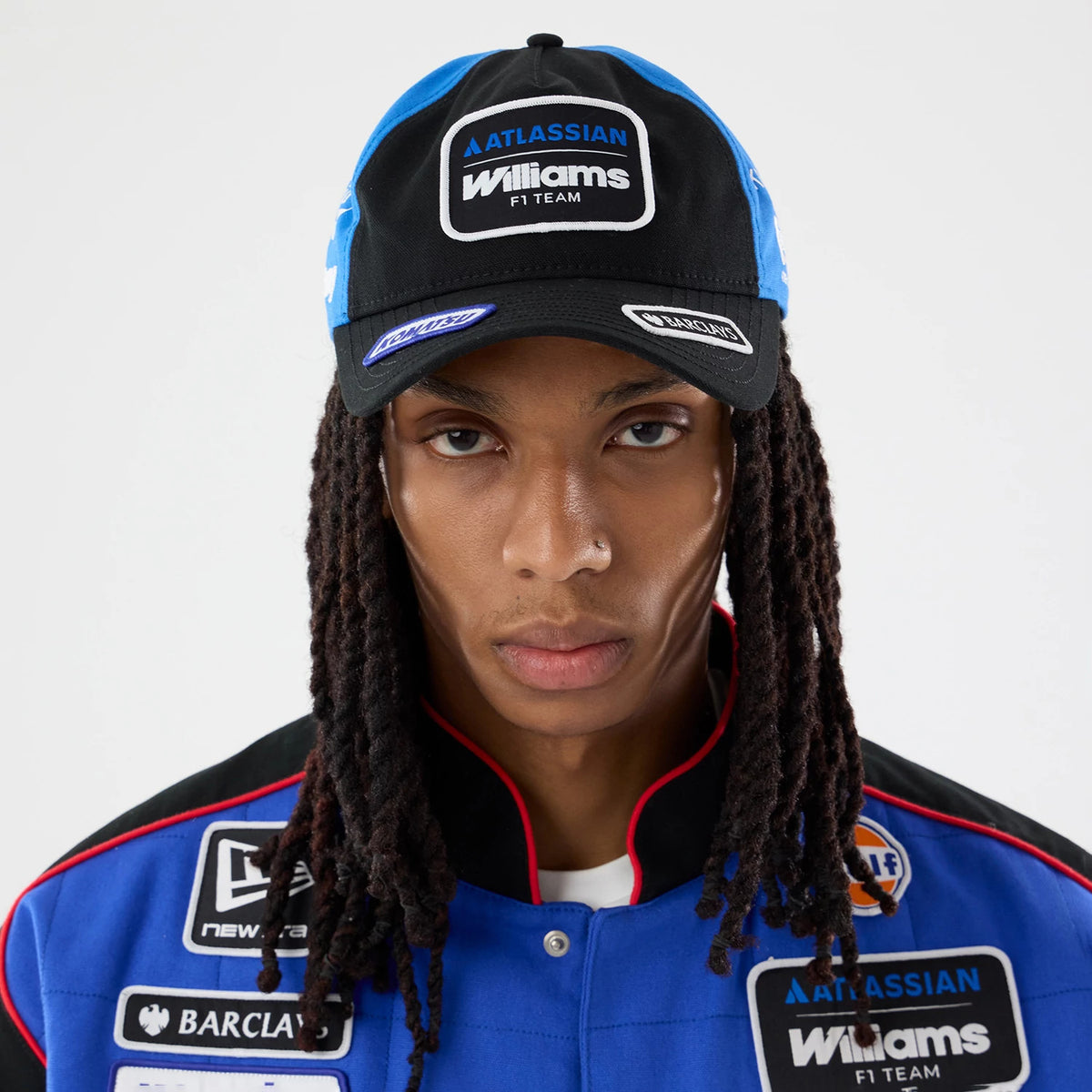 Williams Vegas Race Special Black New Era 9TWENTY A-Frame Adjustable Cap, front view on a model wearing a blue team jacket, showing the embroidered Williams F1 Team logo patch on the black front panel, with a curved black visor.