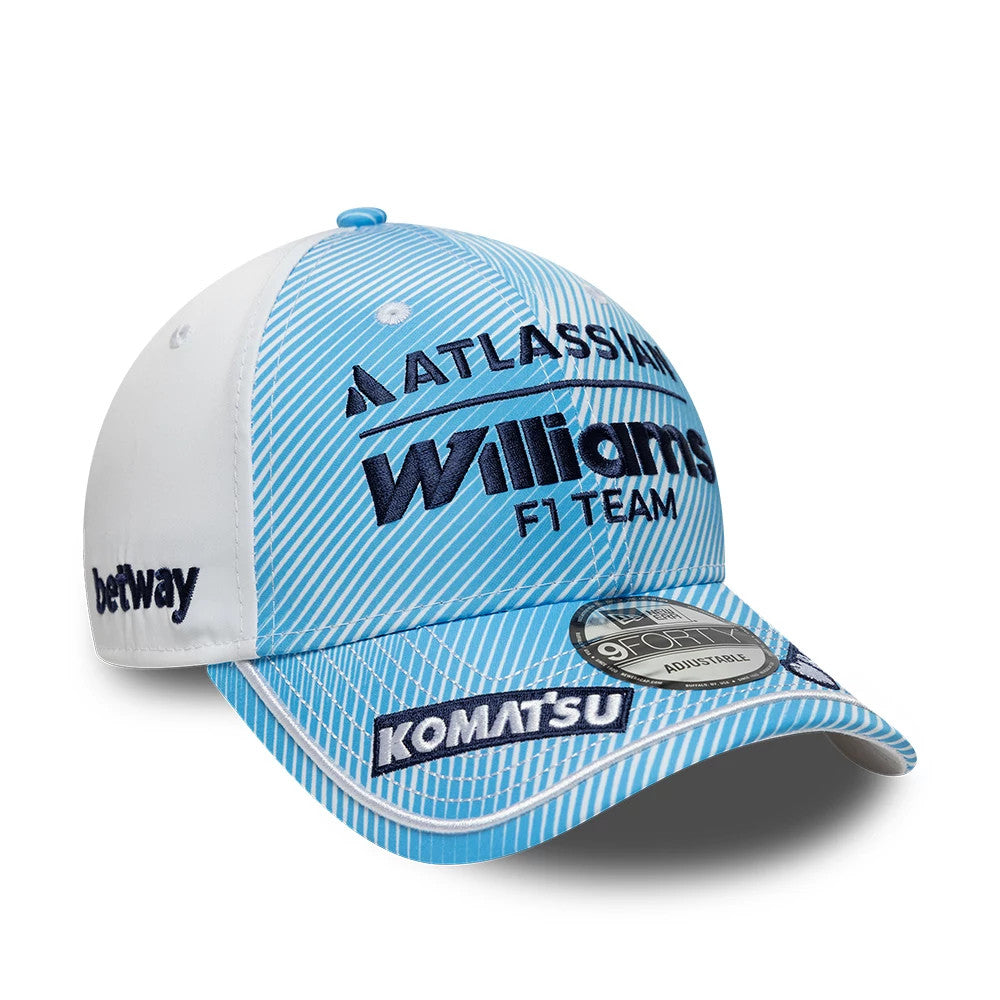 Williams Carlos Sainz Spain Race Special Blue New Era 9FORTY Adjustable Cap, front view showing raised embroidery of Williams F1 Team logo in navy on a light blue striped background, white panels on the sides, and 9FORTY size sticker on the visor.
