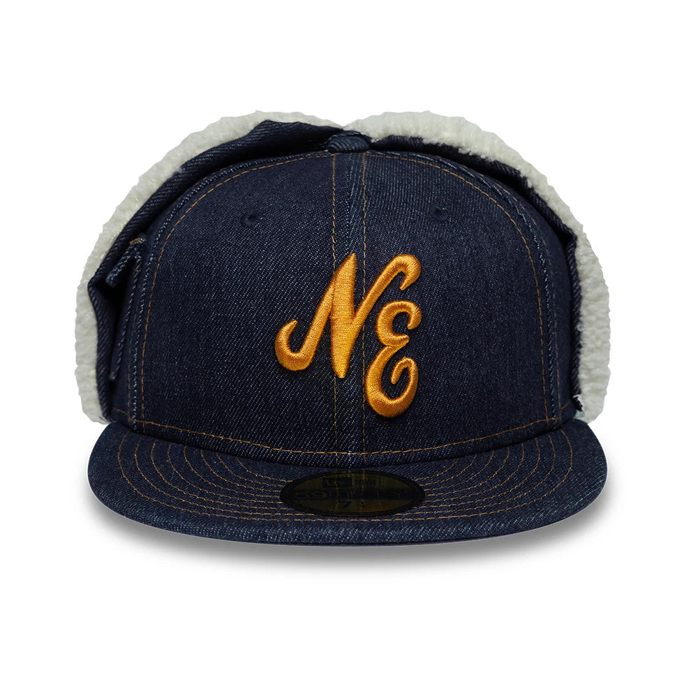 New Era Denim Navy Dogear 59FIFTY Fitted Cap, front view showing the gold raised embroidered NE logo on the structured denim crown, with sherpa-lined dogear flaps and a 59FIFTY size sticker on the flat visor.