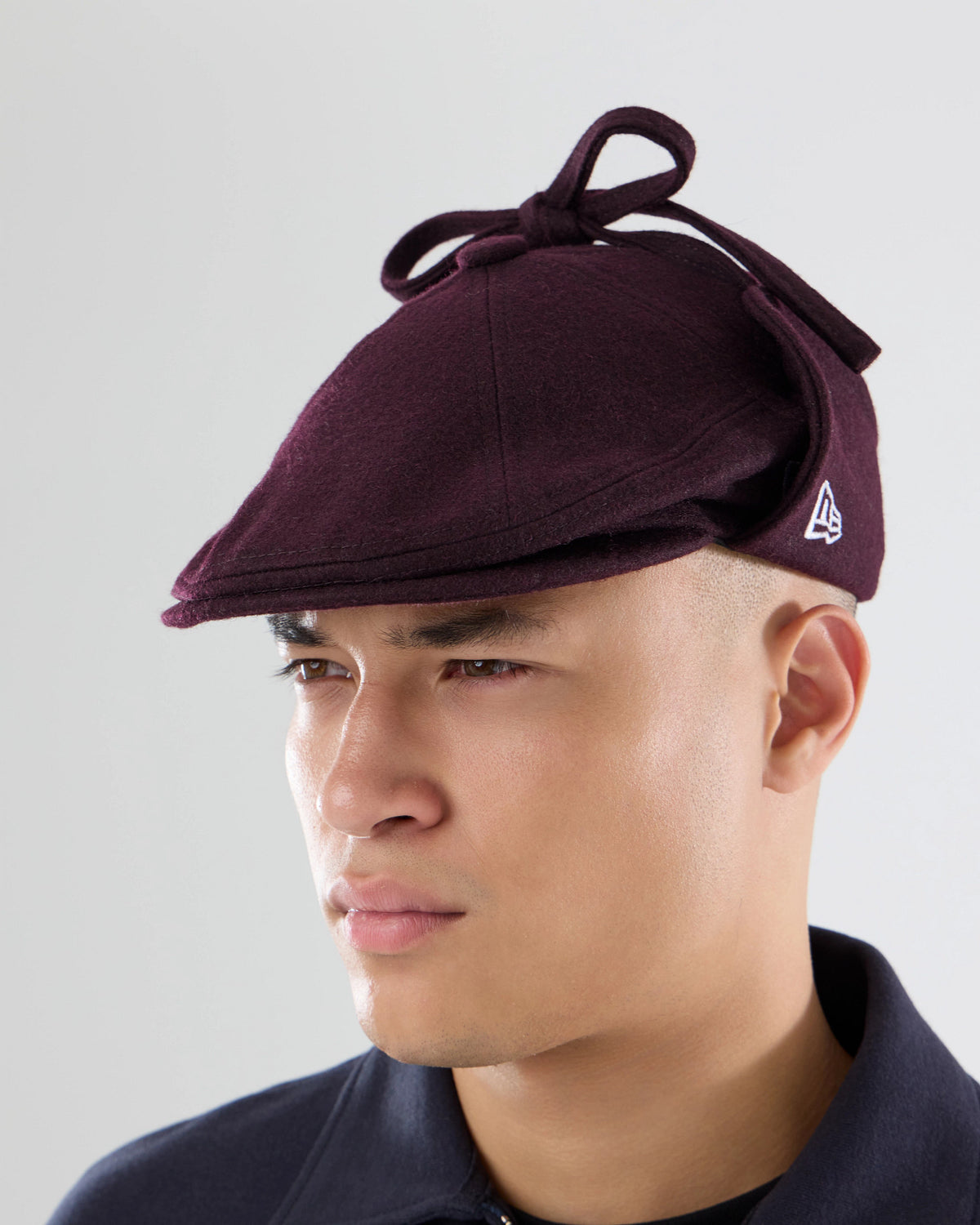 Pictured is this New Era Wool Downflap Driver cap in dark brown. 2