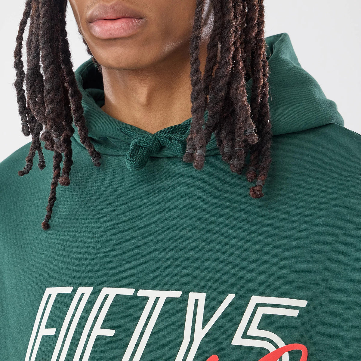 New Era Carlos Sainz Team Fifty5 Smooth Dark Green Oversized Pullover Hoodie, front view on a model featuring a detailed look at the Fifty5 graphic across the chest, the green hood with drawstrings, and part of the neckline.