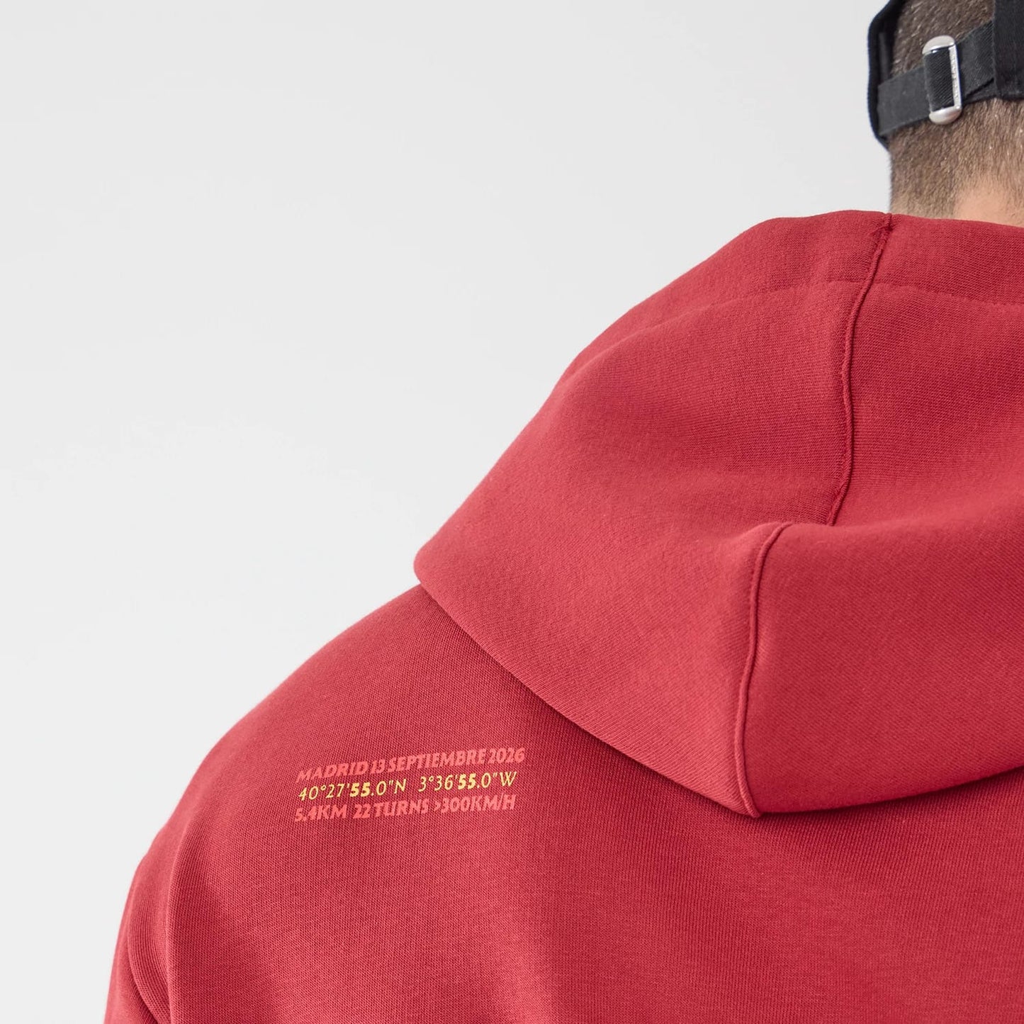 The model is wearing this Carlos Sainz Team Fifty5 Madrid Oversized Pullover Hoodie in dark red. 7