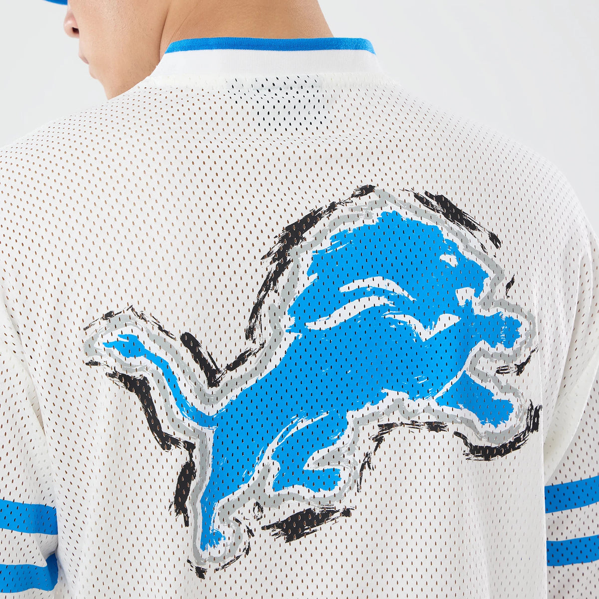 The model is wearing this NFL International Games 2026 Graphic Detroit Lions Mesh Jersey in white. 7