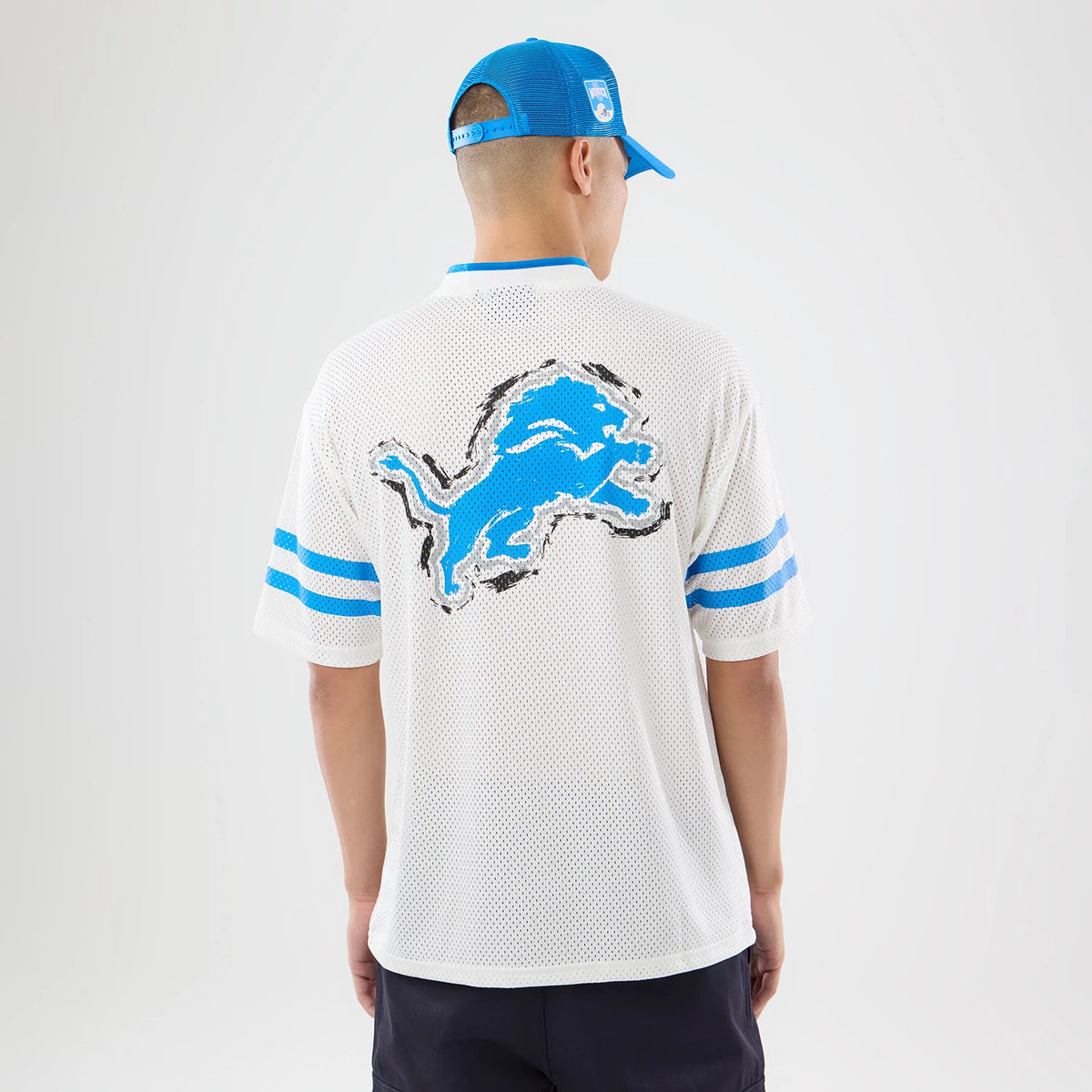 The model is wearing this NFL International Games 2026 Graphic Detroit Lions Mesh Jersey in white. 2