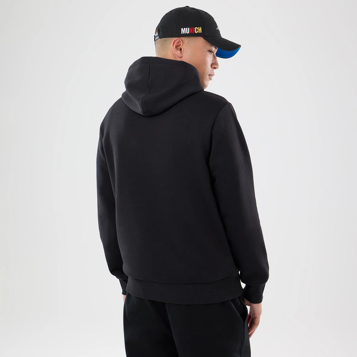 New Era Detroit Lions NFL Patch Black Pullover Hoodie, back view on a model showing the plain black hooded sweatshirt design with a relaxed fit, featuring long sleeves, and a ribbed hem.