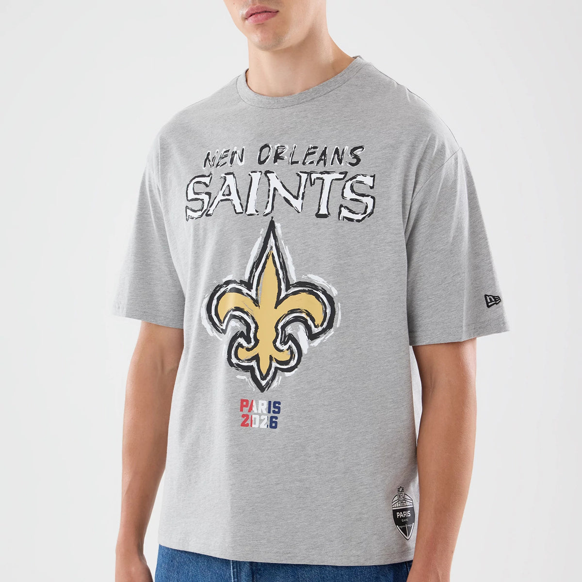 New Era New Orleans Saints NFL Graphic Slogan Grey Oversized T-Shirt, front view on a model featuring the New Orleans Saints logo prominently in yellow with black outlining, text reading New Orleans Saints above it.