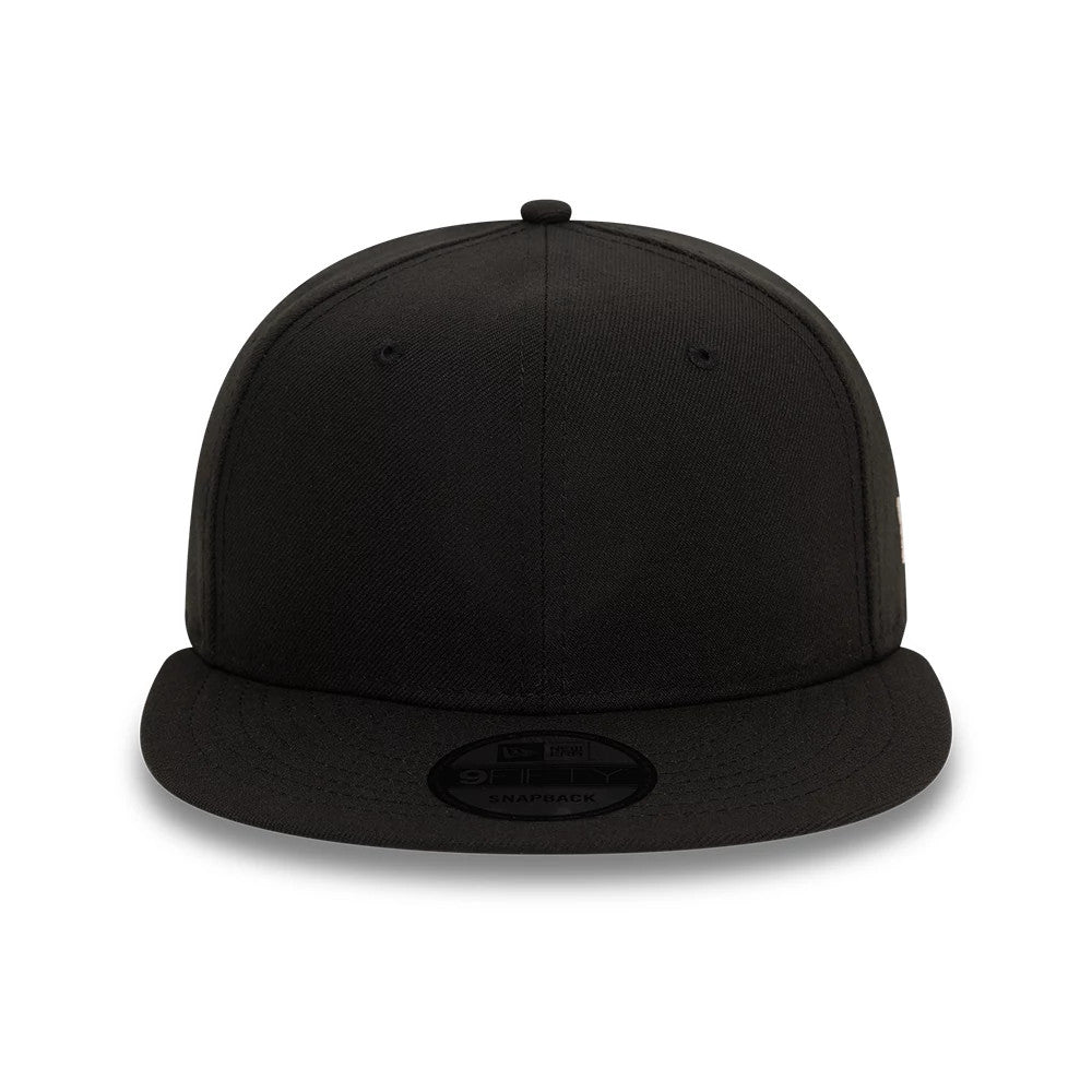 New Era Essential Black 9FIFTY Snapback Cap, front view showing the plain black front panels with a flat visor and a black 9FIFTY size sticker on top, featuring eyelets and a matching top button on the crown.